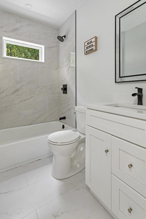 96 Dutton St, Malden, MA 02148 - bathroom featuring marble look tiles, vanity, and shower / bathtub combination