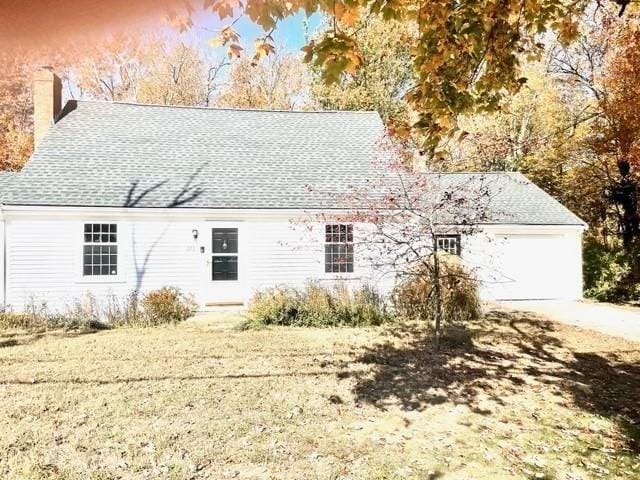 exterior space with a garage and a lawn