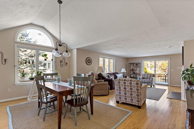 dining room featuring lofted ceiling and light hardwood / wood-style floors