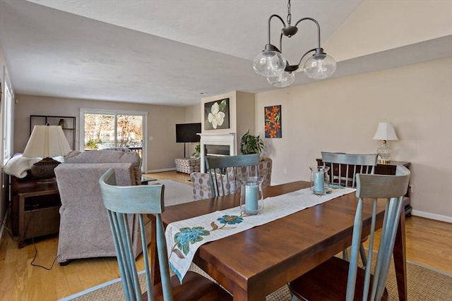 dining space featuring light wood-type flooring and a notable chandelier