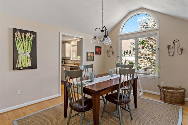 dining room with lofted ceiling, light hardwood / wood-style floors, and sink