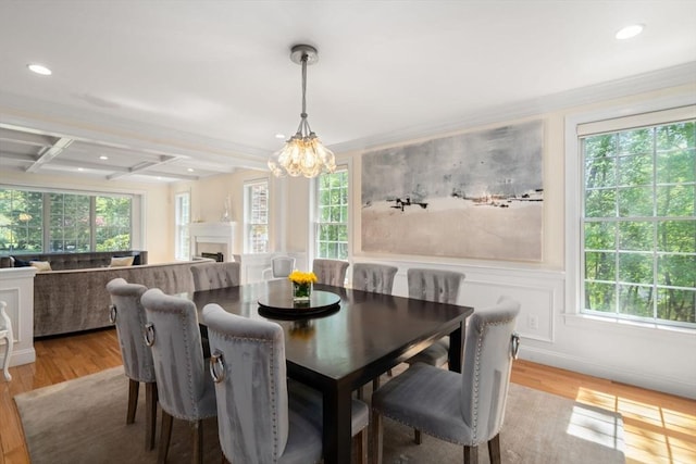 dining room featuring wood finished floors, a chandelier, beamed ceiling, recessed lighting, and a fireplace