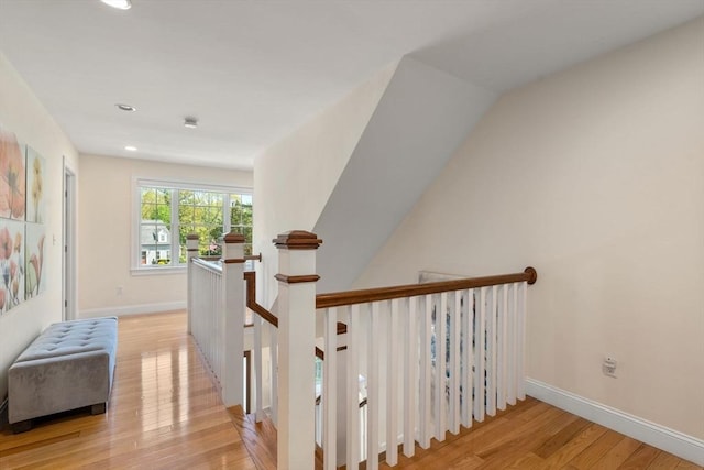hallway with light wood finished floors, recessed lighting, baseboards, and an upstairs landing