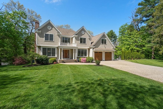 view of front of property featuring a chimney, driveway, a front yard, and a garage