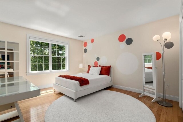 bedroom with wood finished floors and baseboards