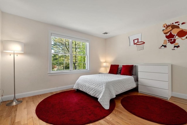 bedroom featuring baseboards and wood finished floors