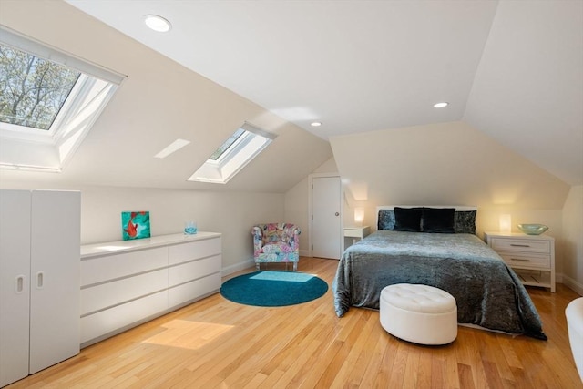 bedroom with a skylight, lofted ceiling, wood finished floors, baseboards, and recessed lighting
