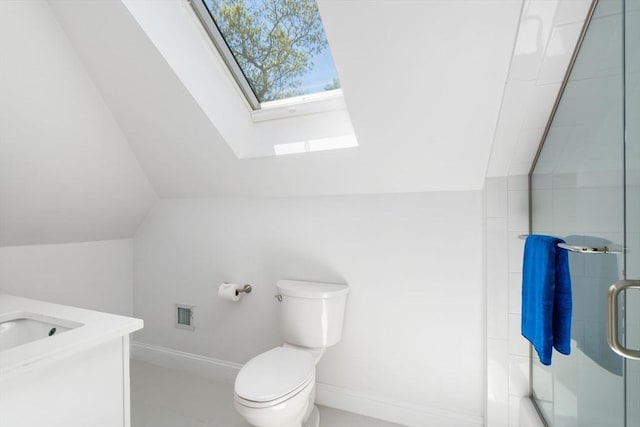 bathroom with a skylight, a shower stall, lofted ceiling, toilet, and vanity