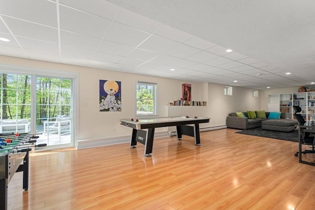 game room with a drop ceiling, baseboards, light wood-type flooring, a baseboard radiator, and recessed lighting
