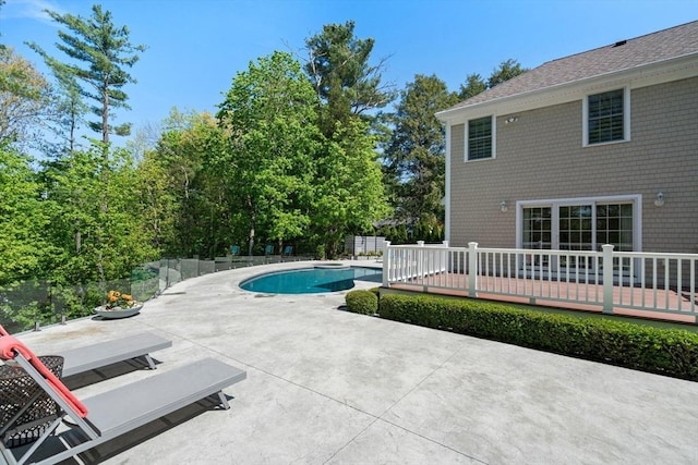 view of swimming pool featuring a wooden deck, a patio area, and fence