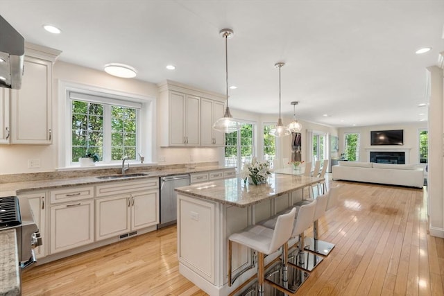 kitchen featuring appliances with stainless steel finishes, a sink, open floor plan, plenty of natural light, and recessed lighting