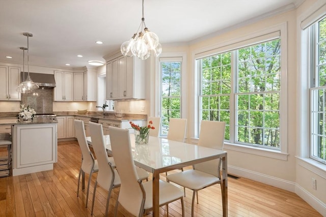 dining area featuring light wood-type flooring, baseboards, a chandelier, ornamental molding, and recessed lighting