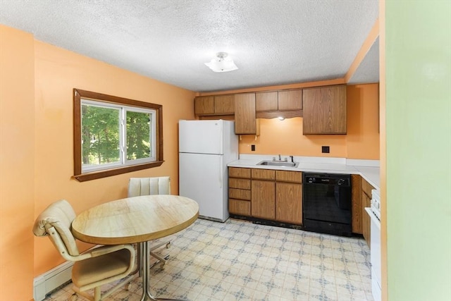 209 S St, Wrentham, MA 02093 - kitchen with black dishwasher, freestanding refrigerator, a sink, baseboard heating, and light countertops