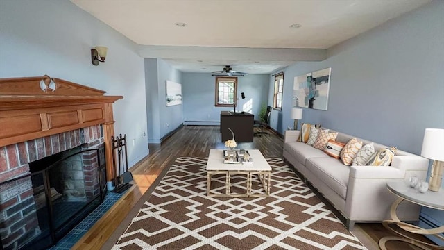 628 Malden St, Revere, MA 02151 - living room with baseboard heating, wood finished floors, a ceiling fan, a fireplace, and baseboards