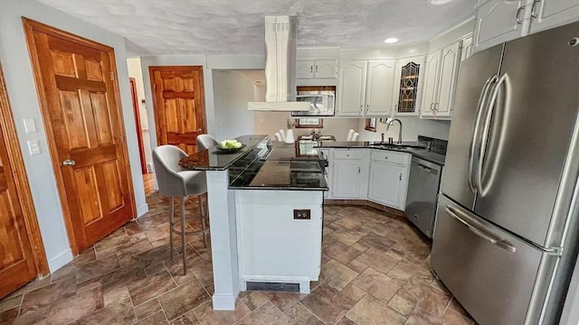 628 Malden St, Revere, MA 02151 - kitchen with stainless steel appliances, dark stone finish flooring, white cabinets, recessed lighting, and a textured ceiling