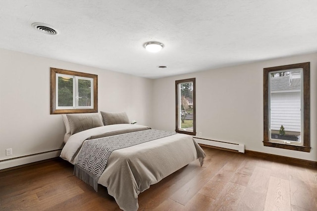 126 Prospect Hill St, Taunton, MA 02780 - bedroom featuring a baseboard radiator, wood finished floors, baseboards, and a textured ceiling