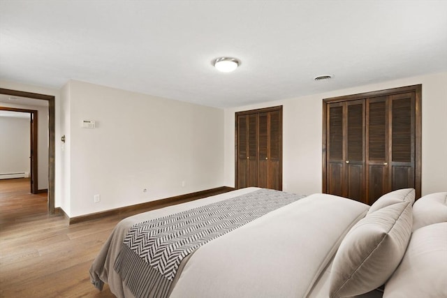 126 Prospect Hill St, Taunton, MA 02780 - bedroom featuring baseboard heating, wood finished floors, multiple closets, and baseboards