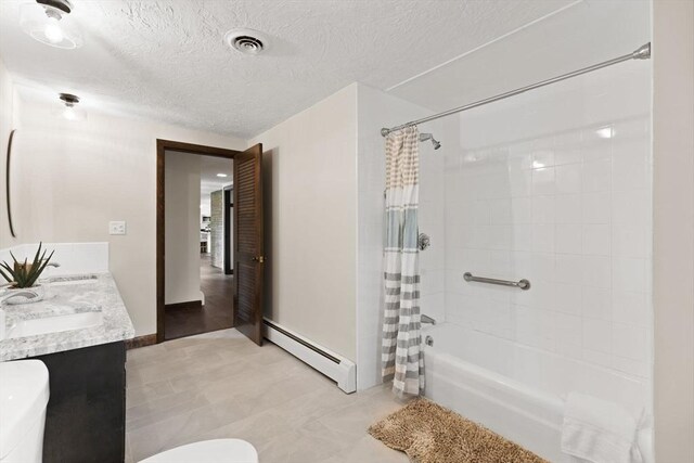126 Prospect Hill St, Taunton, MA 02780 - bathroom with a baseboard heating unit, toilet, shower / bath combo, double vanity, and a textured ceiling