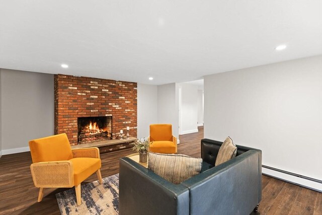 126 Prospect Hill St, Taunton, MA 02780 - living area with baseboard heating, wood finished floors, baseboards, a brick fireplace, and recessed lighting