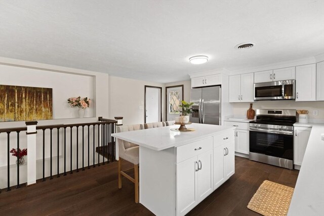126 Prospect Hill St, Taunton, MA 02780 - kitchen featuring appliances with stainless steel finishes, dark wood-style flooring, light countertops, a kitchen island, and white cabinetry