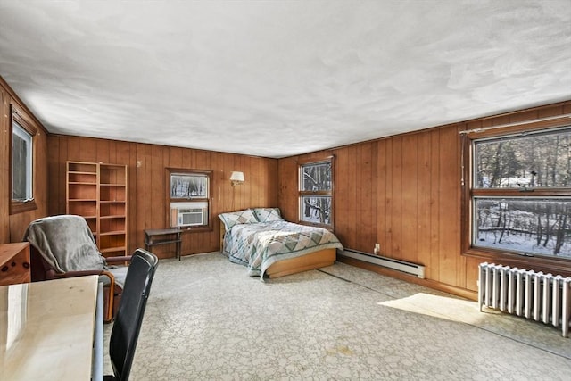 bedroom featuring radiator heating unit, wooden walls, cooling unit, and a baseboard heating unit