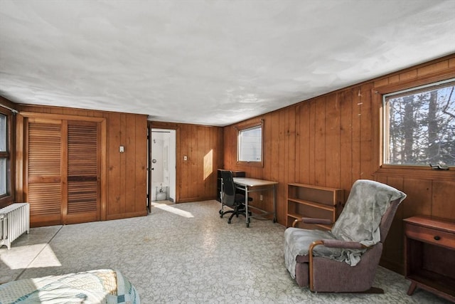 home office featuring wood walls and radiator heating unit