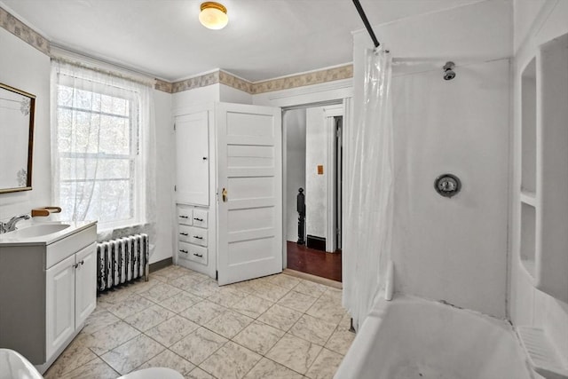 bathroom with radiator heating unit, vanity, and shower / bath combo