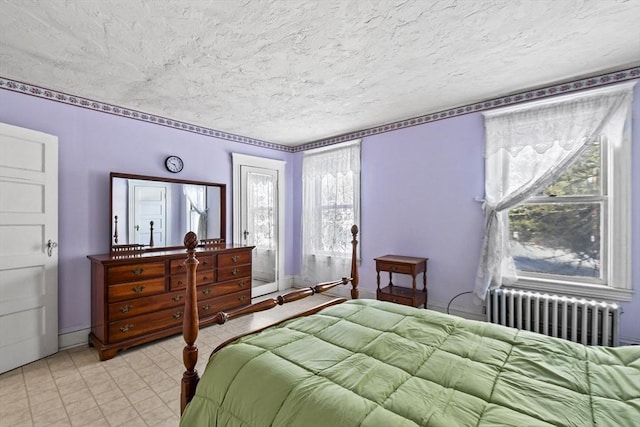 bedroom featuring radiator heating unit and a textured ceiling