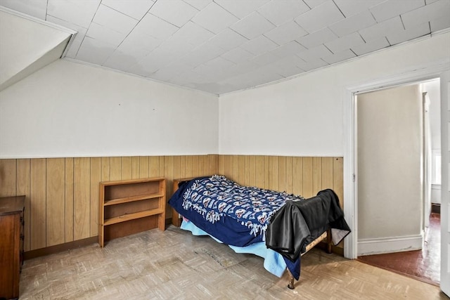 bedroom featuring parquet flooring and wooden walls