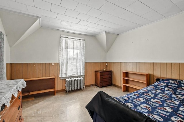 bedroom with wooden walls, radiator heating unit, crown molding, and vaulted ceiling