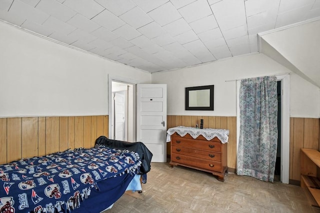 bedroom featuring light parquet floors and wood walls