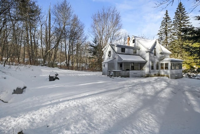 view of snow covered exterior featuring a sunroom