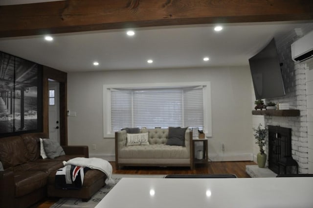 living room featuring dark wood-type flooring, beam ceiling, a brick fireplace, and an AC wall unit