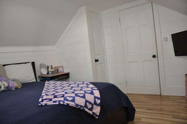 bedroom with vaulted ceiling and hardwood / wood-style floors