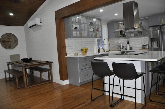 kitchen with black electric stovetop, island range hood, gray cabinets, and dark wood-type flooring