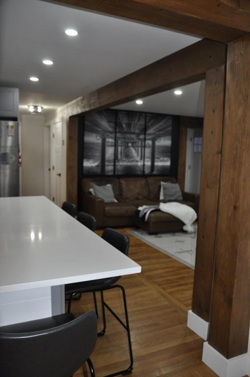 dining area with beam ceiling and dark hardwood / wood-style floors