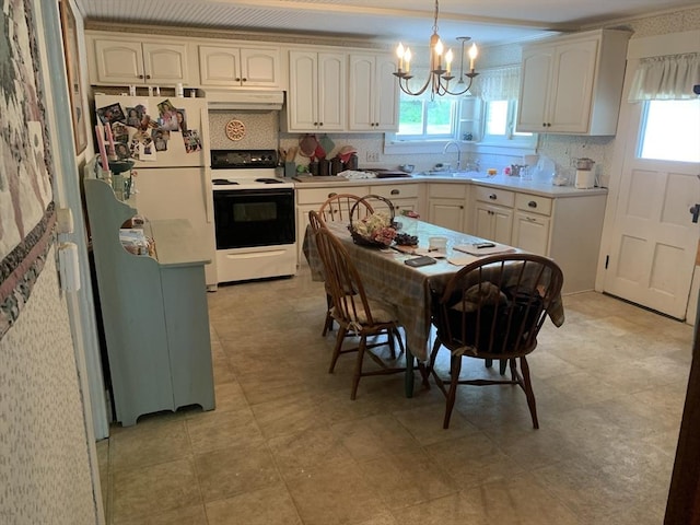 293 Washington, Warren, MA 01083 - kitchen with white appliances, under cabinet range hood, tasteful backsplash, light countertops, and decorative light fixtures
