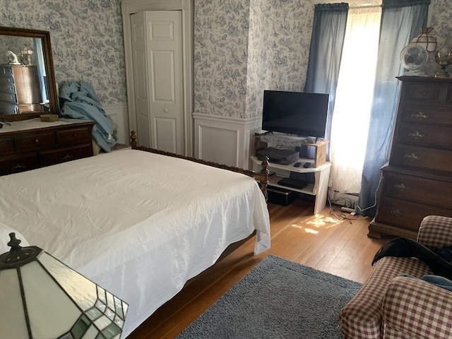 293 Washington, Warren, MA 01083 - bedroom featuring wallpapered walls, wainscoting, and hardwood / wood-style flooring