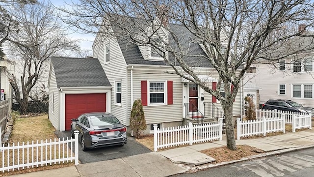 view of front of property with a shingled roof, driveway, and a fenced front yard