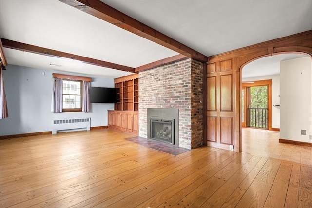 4 Farmland Rd, Saugus, MA 01906 - unfurnished living room with radiator heating unit, beam ceiling, hardwood / wood-style floors, baseboards, and a brick fireplace