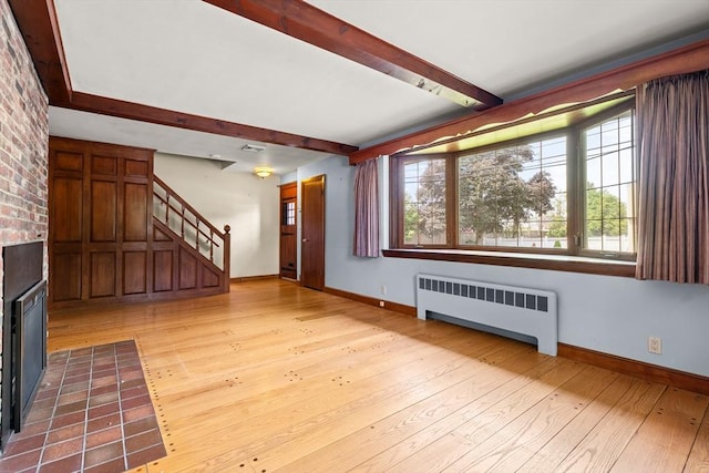 4 Farmland Rd, Saugus, MA 01906 - unfurnished living room with radiator, beam ceiling, baseboards, light wood-style floors, and stairway