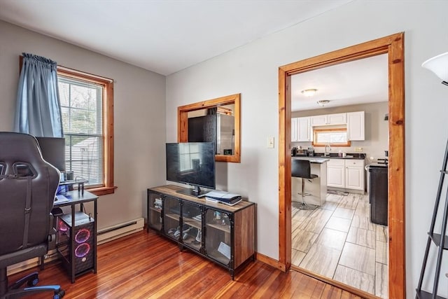 interior space featuring a baseboard heating unit and hardwood / wood-style floors