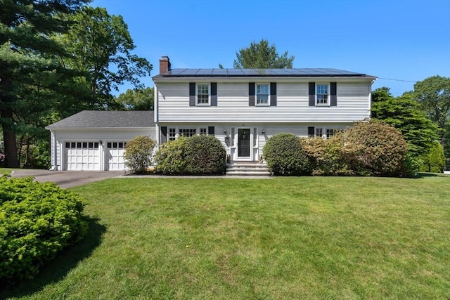 1 Pleasantview Ter, Framingham, MA 01701 - colonial-style house with a chimney, a garage, roof mounted solar panels, a front yard, and concrete driveway