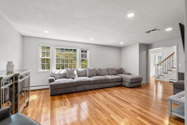 1 Pleasantview Ter, Framingham, MA 01701 - living area featuring a baseboard heating unit, light wood-style floors, a textured ceiling, recessed lighting, and stairs
