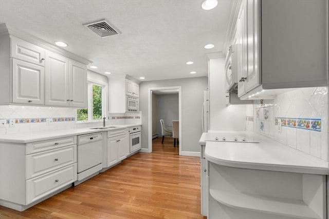 1 Pleasantview Ter, Framingham, MA 01701 - kitchen featuring white appliances, open shelves, tasteful backsplash, light wood-style floors, and white cabinetry