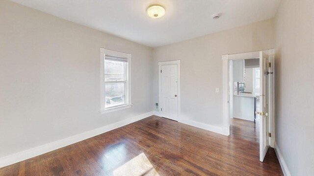 unfurnished room with dark wood-type flooring