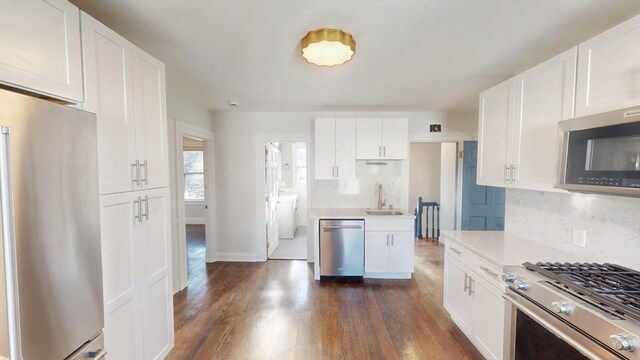 kitchen with white cabinets, stainless steel appliances, and dark wood-type flooring