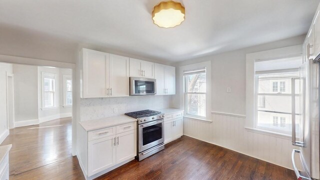 kitchen with white cabinets, stainless steel appliances, and dark hardwood / wood-style floors