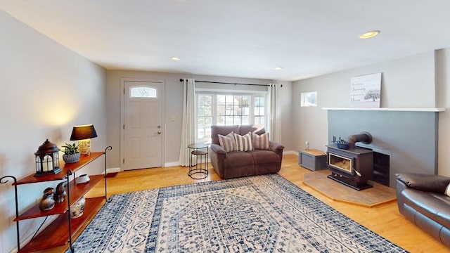 living room with light hardwood / wood-style floors and a wood stove