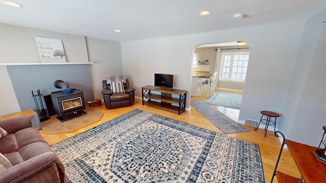 living room with hardwood / wood-style flooring and a wood stove